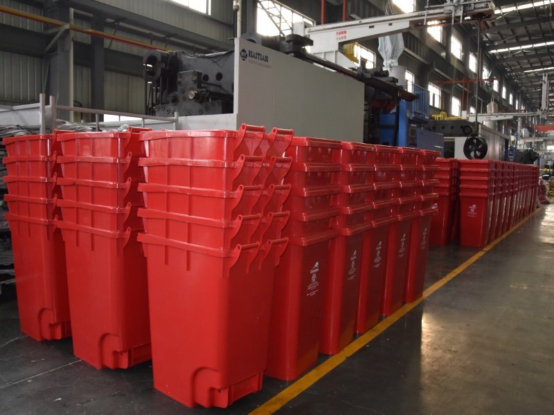 Red plastic waste bin are stacked together in the factory