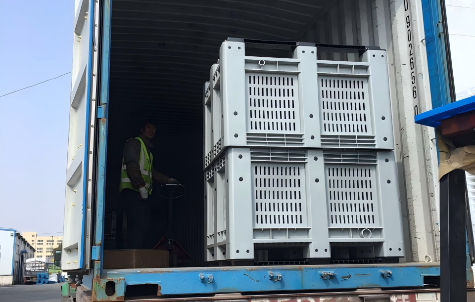 Vented plastic pallet boxes stacked and loaded for transport