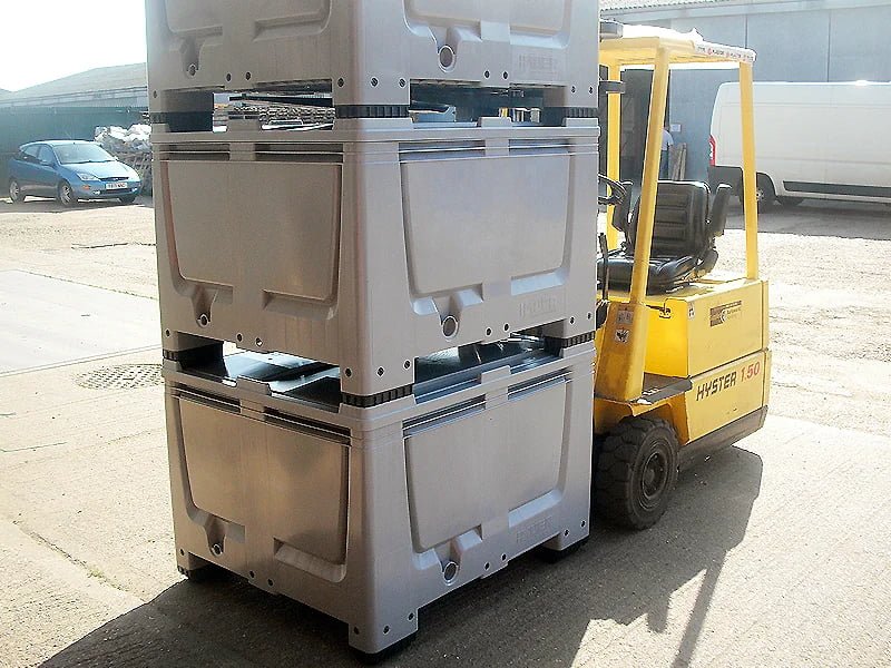 Stacked rigid plastic pallet boxes in warehouse storage